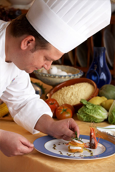 Chef Antonio Carmona cooking Traditional garlic, fish and potato stew with fried corn bread